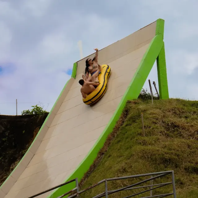 Pessoas em uma boia amarela na rampa da atração Arrepius.