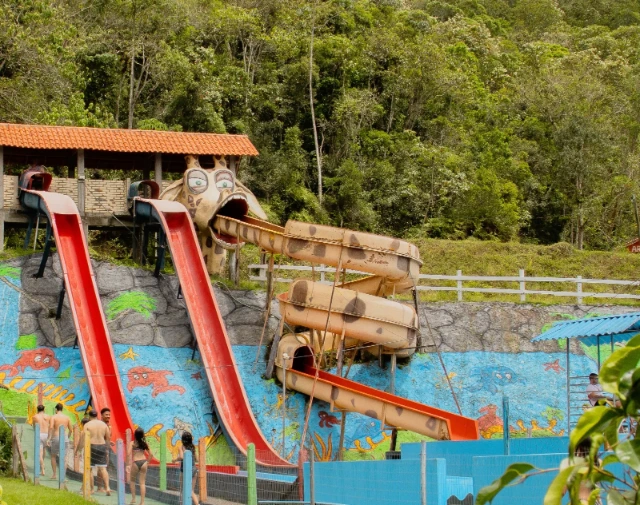 Vista a distância da atração Girafa, um toboágua fechado e em em caracol com pintura de girafa..